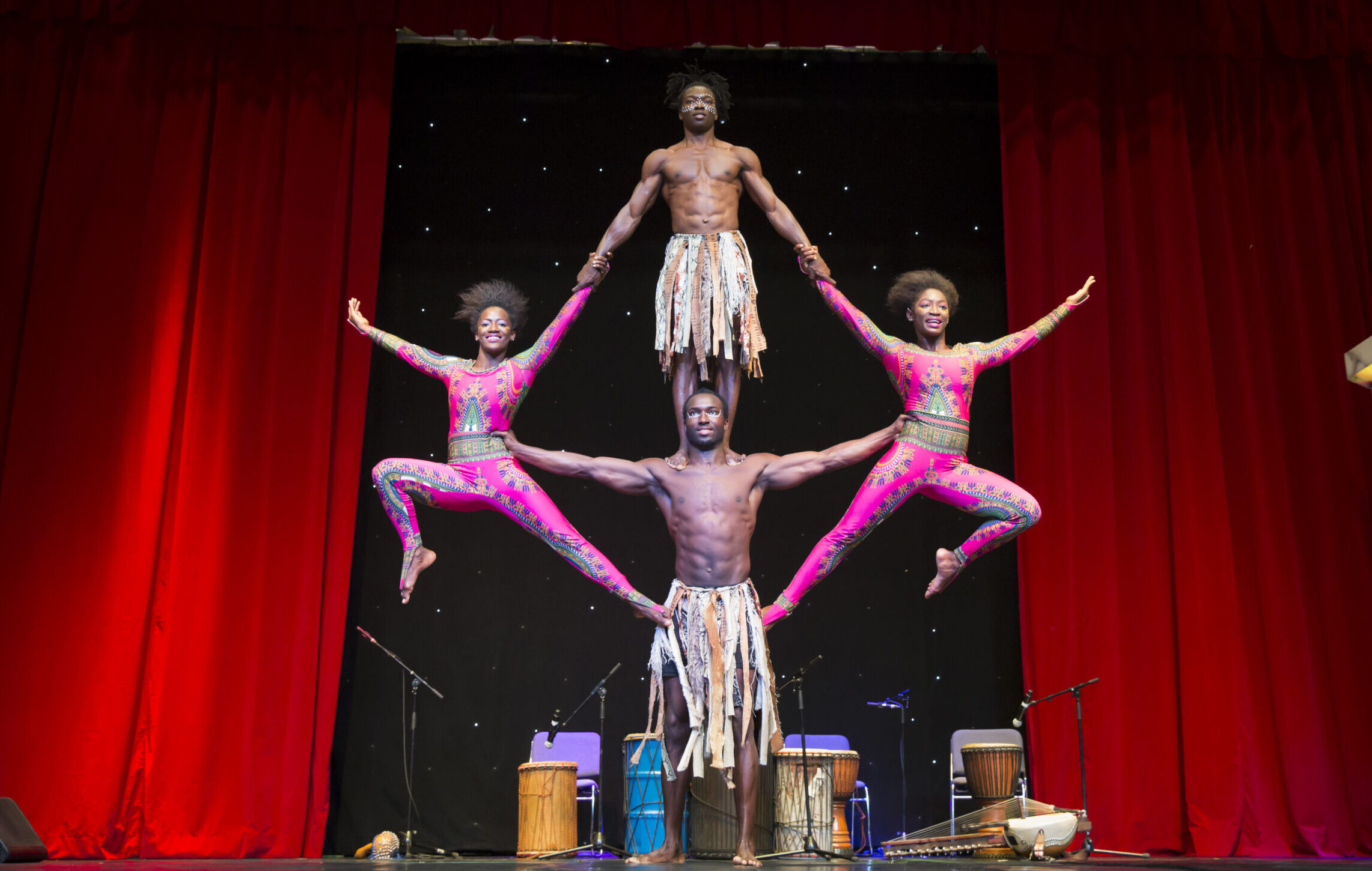 Image of International stage performers. Artists performing an acrobatic maneuver in formation.
